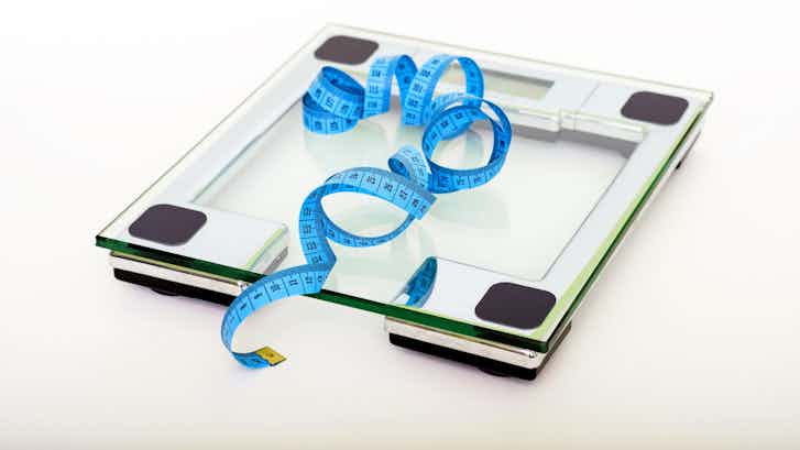 Blue tape measuring on clear glass square weighing scale 53404